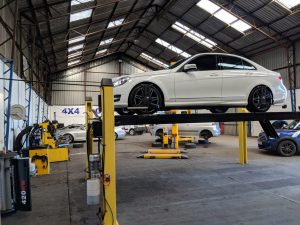 White car on yellow hydraulic lift